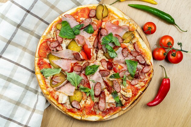 Włoska, Domowa Pizza Z Mięsem, Boczkiem, Salami I Ostrą Papryką Na Drewnianym Stole.