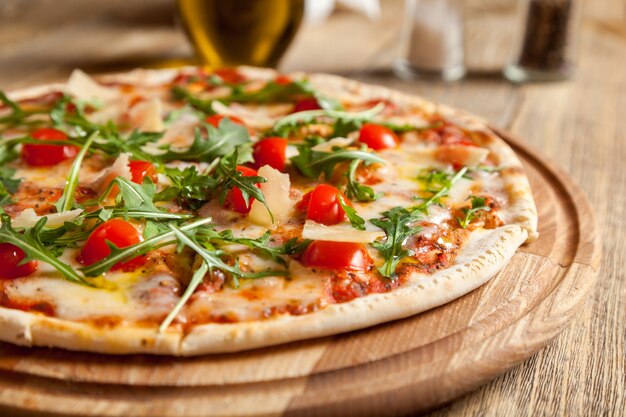 Włoska pizza Caprese leży na pięknym drewnianym stole