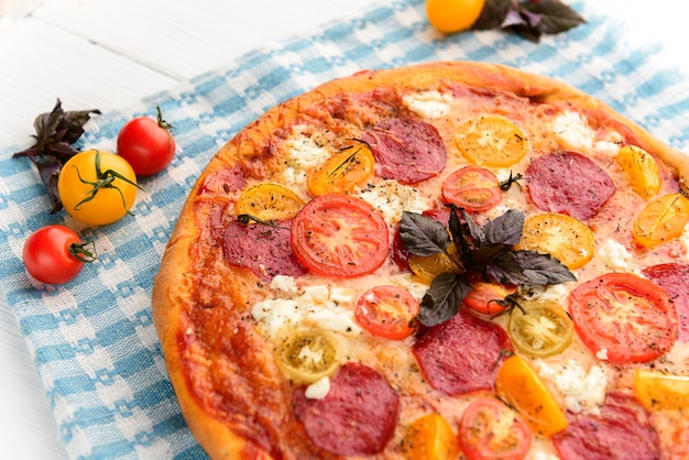 Włoska pizza Pepperoni z salami i serem na rustykalnym drewnianym białym tle