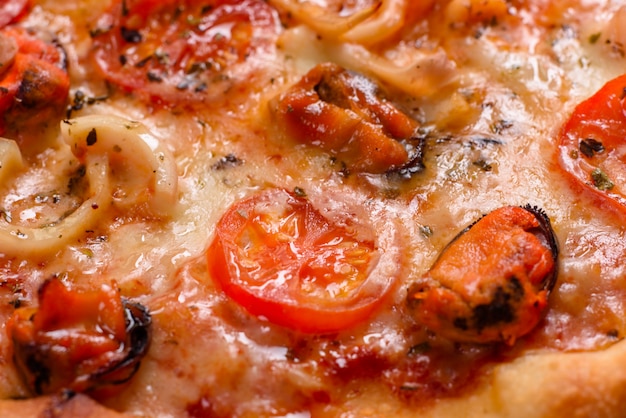 Włoska pizza z owocami morza z krewetkami, kalmarami, małżami, świeżymi ziołami i mozzarellą