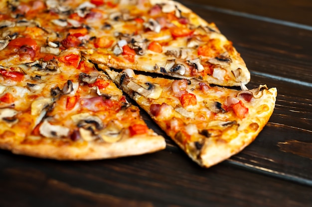 włoska pizza z pieczarkami, pomidorami i serem na drewnie