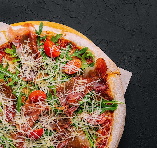 Włoska pizza z prosciutto rukolą i pomidorami