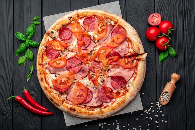 Włoska pizza z szynką, kiełbasą, pieczarkami, pomidorami i cebulą