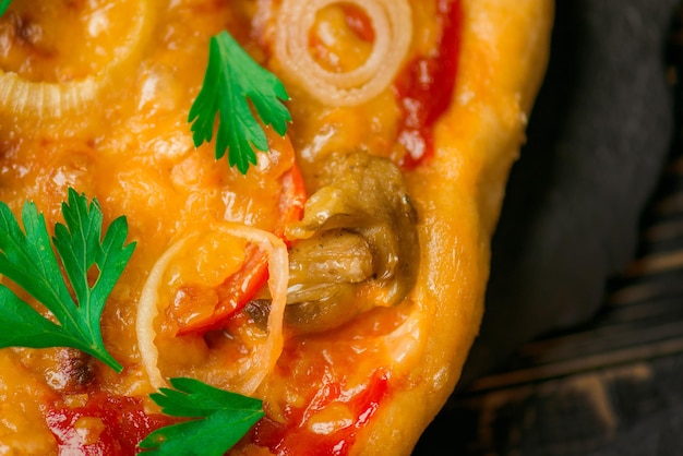 Włoska pizza z szynką pieprz bazylia czarne oliwki pomidory pieczarki cebula Zbliżenie strzał pizzy na stole Świeżo upieczona tradycyjna pizza
