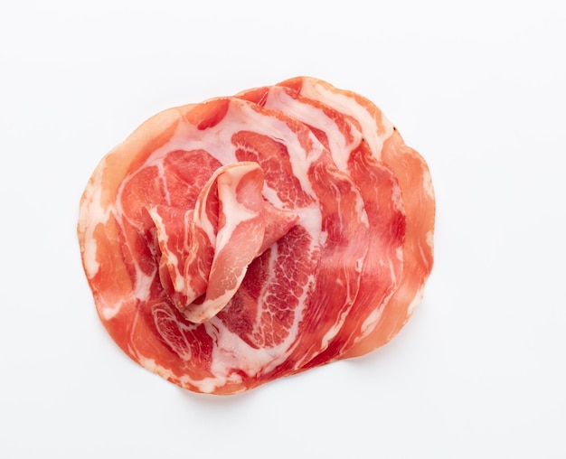 Włoska szynka prosciutto crudo lub jamon. Surowa szynka. Na białym tle.