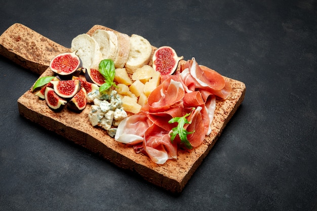 Zdjęcie włoska szynka prosciutto lub hiszpańska szynka, ser, figi i chleb