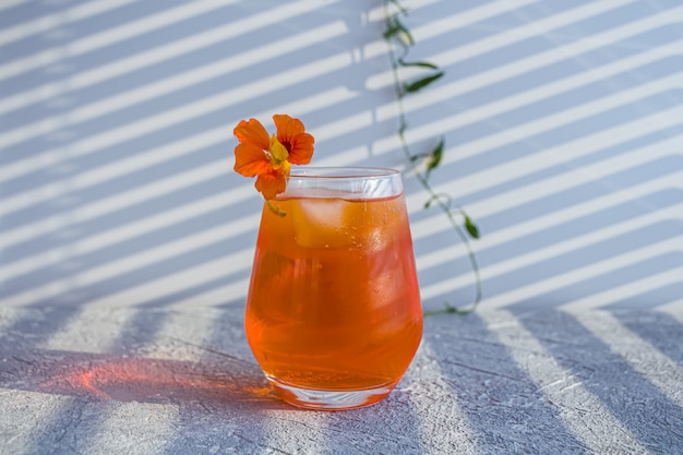 Włoski koktajl alkoholowy Aperol Spritz z kostkami lodu i kwiatem