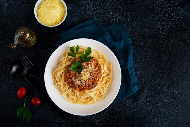 Włoski makaron bolognese z zielenią na czarnym tle, kopia przestrzeń