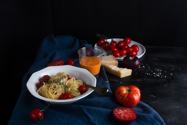 Włoski makaron spaghetti ze smażonym pomidorem cherry i tymiankiem, widok z boku
