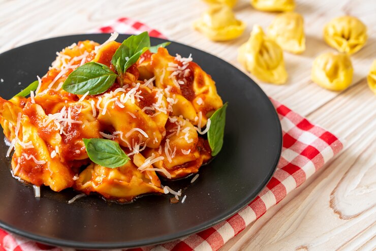 Zdjęcie włoski makaron tortellini z sosem pomidorowym - po włosku