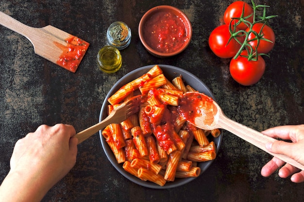 Włoski makaron w misce ze świeżym sosem pomidorowym. Wegańska miska z makaronem w sosie pomidorowym.