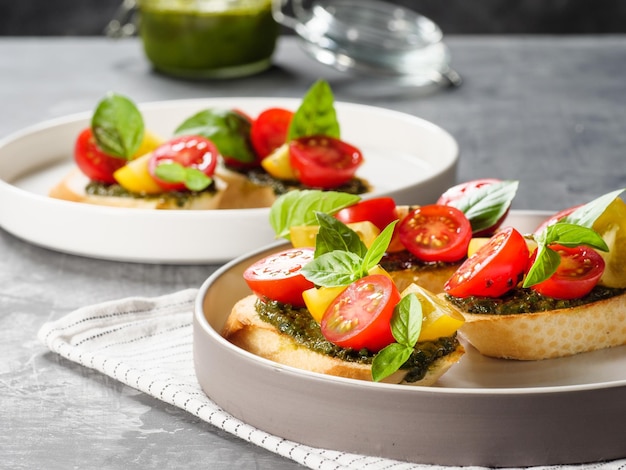 Włoskie antipasti bruschetta z pomidorową bazylią i pesto na szarym stole