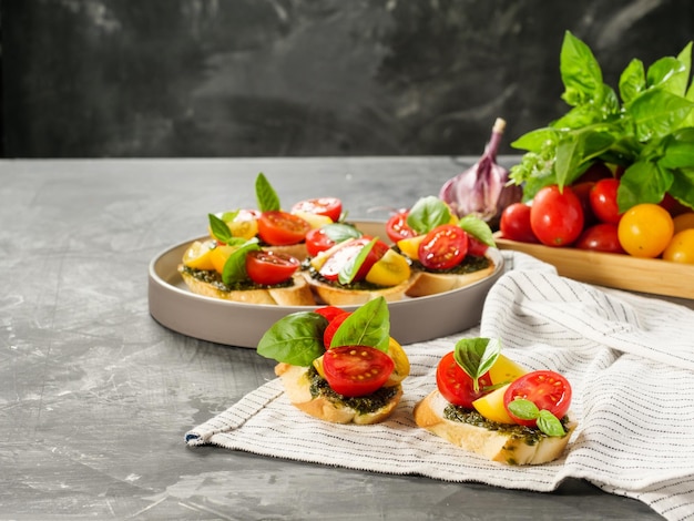 Włoskie antipasti bruschetta z pomidorową bazylią i pesto na szarym stole