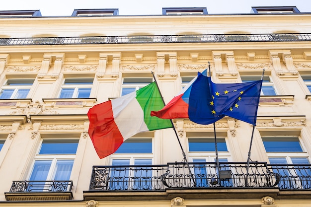 Włoskie i europejskie flagi oraz inne flagi na balkonie.