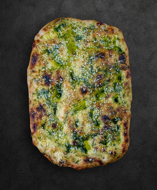 Włoskie pieczywo focaccia z pesto sezamem i parmezanem rzymską pizzą prostokątne na ciemnym tle