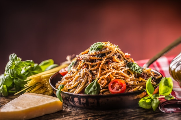 Włoskie spaghetti z sosem pomidorowym z oliwą bazyliową i parmezanem na starej patelni.