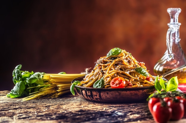 Włoskie spaghetti z sosem pomidorowym z oliwą bazyliową i parmezanem na starej patelni.