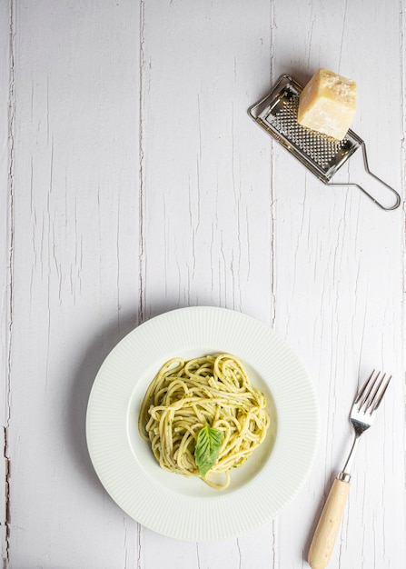 Włoskie spaghetti ze świeżym domowym sosem pesto Spożywane na białej drewnianej desce
