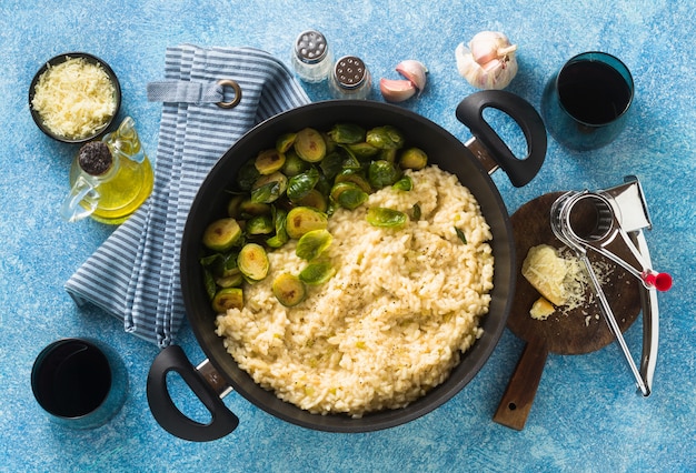 Włoskie wiosenne risotto z brukselką i parmezanem na stole.