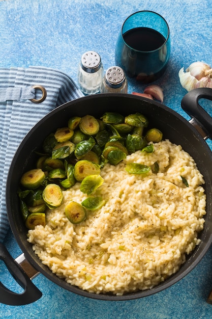 Włoskie wiosenne risotto z brukselką i parmezanem na stole.