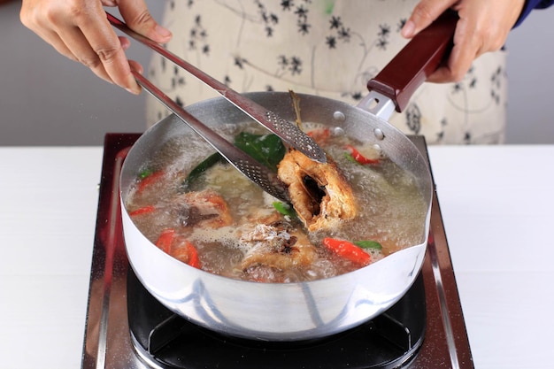 Włóż rybę do smażenia na mleku (Bandeng) do zupy na patelnię, krok po kroku Sop Bandeng na Chiński Nowy Rok. Pindang Bandeng Milkfish jest lokalną tradycją podczas Imlek
