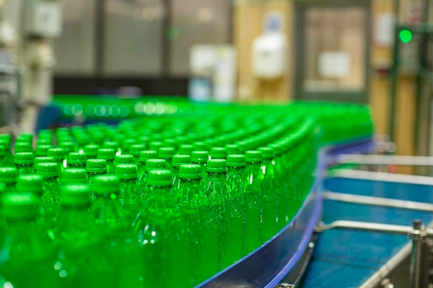 Wnętrze fabryki napojów Przenośnik przepływający z butelkami na sok zielony