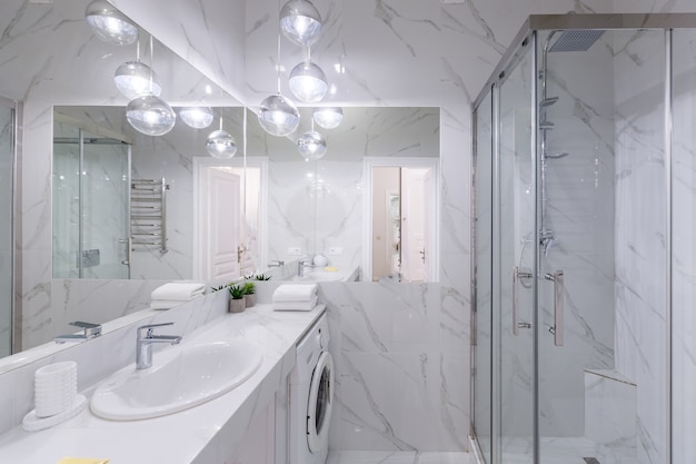 Wnętrze łazienki z białymi marmurowymi kafelkami i nowoczesnym prysznicem
