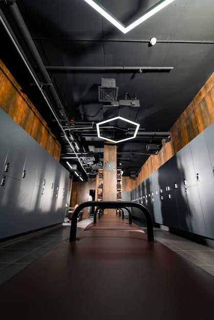 Wnętrze publicznej szatni ze skórzanymi ławkami i szafkami w szatni w luksusowym centrum siłowni Pionowe ujęcie Koncepcja sportu i rekreacji