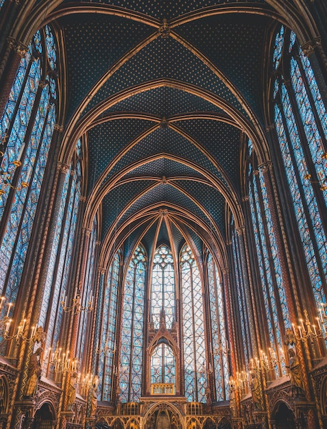 Zdjęcie wnętrze saintechapelle w paryżu z witrażami, sklepieniem i zapalonymi świecami