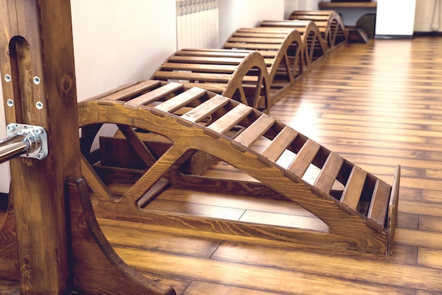Wnętrze sali gimnastycznej z drewnianymi ławkami do jogi