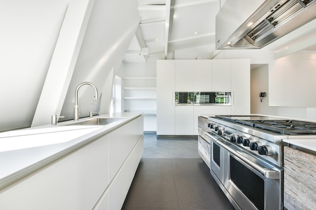 Wnętrze współczesnej kuchni z białymi meblami i błyszczącymi urządzeniami w mieszkaniu