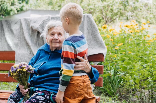 Zdjęcie wnuk daje kwiat babci wnuk i babcia spędzają czas razem babcia