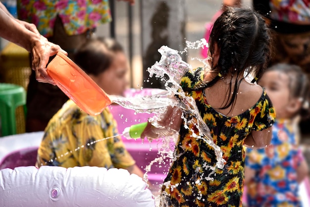 Zdjęcie woda chlapie dziewczynkę na festiwalu songkran w tajlandii