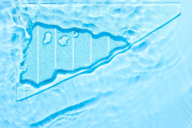 Woda niebieska powierzchnia abstrakcyjne tło Fale i zmarszczki tekstura kosmetycznego wodnego kremu nawilżającego z bąbelkami i przezroczystym szkłem lodowym w środku