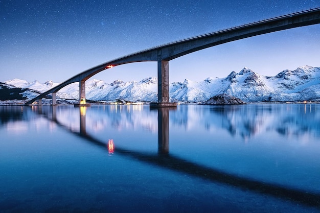Woda pomostowa i nocne niebo z gwiazdami Odbicie na powierzchni wody Naturalny krajobraz w Norwegii w nocy Obraz z podróży