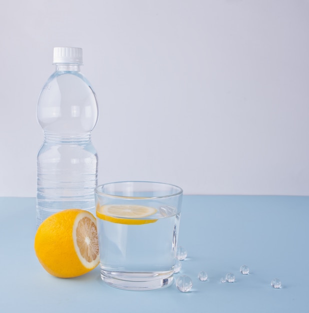 Woda z cytryną na błękitnym stole