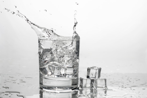 Woda z lodem w szklance z rozpryskami