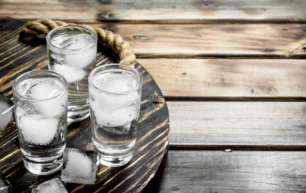 Wódka w kieliszku i kostkach lodu na tacy