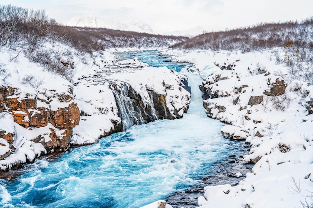 Wodospad Hlauptungufoss „Najbardziej błękitny wodospad Islandii” Niebieska woda przepływa przez kamienie Zimowa Islandia Odwiedź Islandię Wędrówka do wodospadu bruarfoss