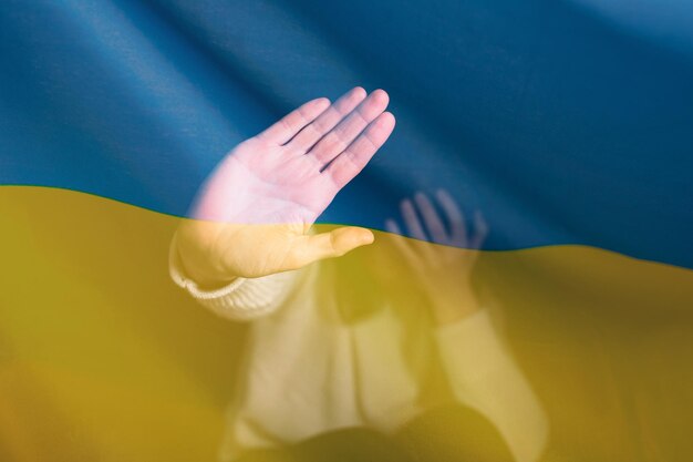 Zdjęcie wojna między rosją a ukrainą kobieta z smutnym widokiem zatrzymaj gest nad flagą ukrainy