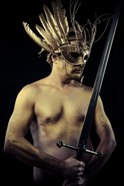 Wojownik w hełmie i mieczu z ciałem pomalowanym na złoty pył
