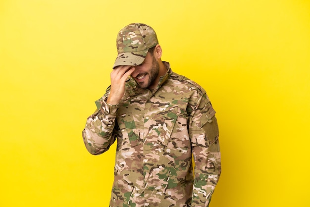 Zdjęcie wojskowy na białym tle śmiejąc się na żółtym tle