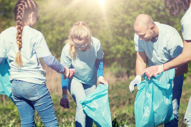 Wolontariusze z workami na śmieci sprzątają park