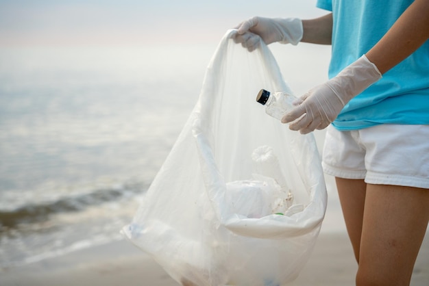 Wolontariusze zbierają śmieci na plaży, a plastikowe butelki są trudne do zapobieżenia rozkładowi