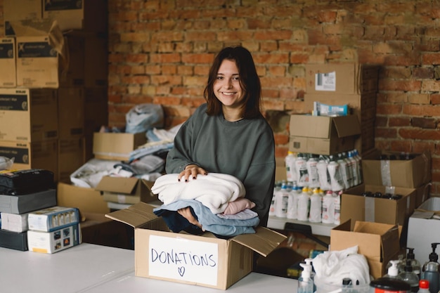 Wolontariuszka nastolatka przygotowująca pudełka z darowiznami dla ludzi Darowizna odzież dla uchodźców wsparcie ofiar wojny Koncepcja pomocy humanitarnejPomaganie ludziom