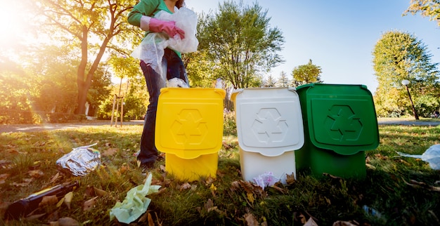 Wolontariuszka sortuje śmieci na ulicy w parku. Pojęcie recyklingu