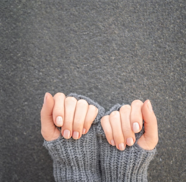 Womans ręce manicure na szarym tle Pionowy płaski transparent kosmetyczka z miejscem na kopię