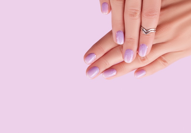 Womans ręce z modnym manicure lawendowym wzorem paznokci na wiosnę