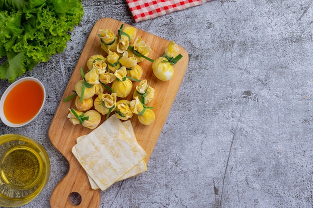 Wonton smażony w głębokim tłuszczu na ciemnej powierzchni.