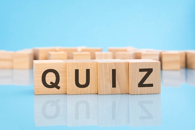 Word Quiz wykonany z drewnianych klocków na niebieskim tle koncepcji biznesowej